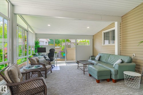 Enclosed sunroom featuring a paneled ceiling with recessed lighting, full-height windows, vinyl siding, and a sliding glass door - 10339 36A Avenue, Edmonton, AB - Outdoor With Deck Patio Veranda With Exterior