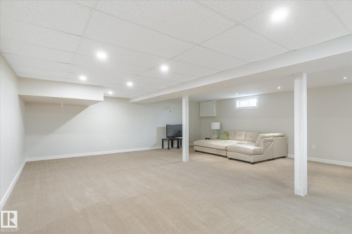 Spacious room featuring neutral carpeting, recessed lighting, and a drop ceiling - 10339 36A Avenue, Edmonton, AB - Indoor Photo Showing Basement