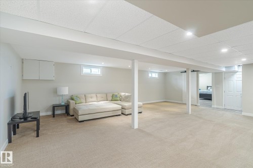Spacious finished basement with neutral carpeting, recessed lighting, and drop ceiling - 10339 36A Avenue, Edmonton, AB - Indoor Photo Showing Other Room