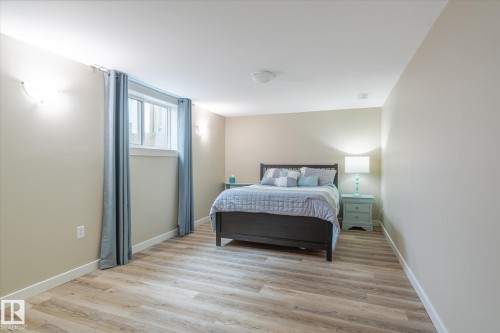 Bright room featuring wood-finish flooring, a window with white trim, and neutral-toned walls - 10339 36A Avenue, Edmonton, AB - Indoor Photo Showing Bedroom