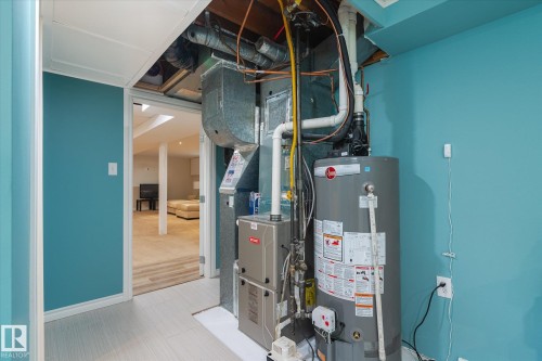 Utility area featuring a water heater, furnace, and exposed ductwork - 10339 36A Avenue, Edmonton, AB - Indoor Photo Showing Basement