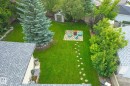 Expansive lawn featuring a stepping stone pathway to a flagstone patio with a built-in fire pit - 10339 36A Avenue, Edmonton, AB  - Outdoor 
