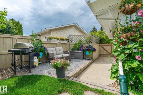 Private outdoor patio space featuring a gravel seating area, concrete pathway, and wood fencing - 10339 36A Avenue, Edmonton, AB - Outdoor