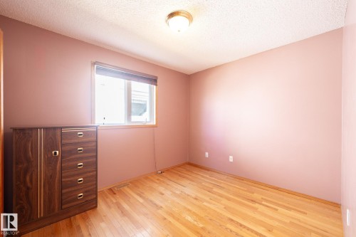 Room featuring wood-finish flooring, a window with a roller blind, and a ceiling-mounted light fixture - 5736 161 Avenue, Edmonton, AB - Indoor Photo Showing Other Room