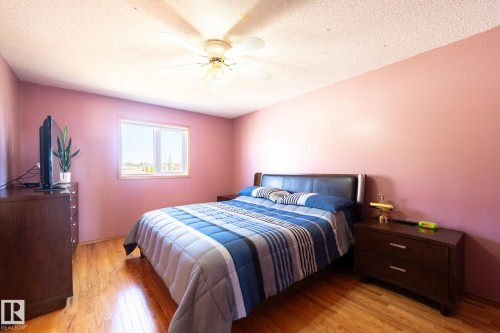 Bedroom featuring wood-finish flooring, a double-pane window, and a ceiling fan with integrated lighting - 5736 161 Avenue, Edmonton, AB - Indoor Photo Showing Bedroom