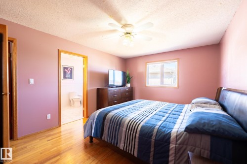 Bedroom featuring wood-finish flooring, a ceiling fan, and a window with a light wood-tone trim - 5736 161 Avenue, Edmonton, AB - Indoor Photo Showing Bedroom