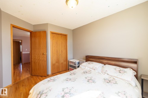 Hardwood-style flooring throughout, featuring a double-door closet with wood-finish doors - 5736 161 Avenue, Edmonton, AB - Indoor Photo Showing Bedroom