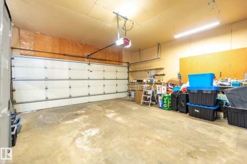 Spacious garage featuring a concrete floor, overhead lighting, and an automatic garage door opener - 5736 161 Avenue, Edmonton, AB - Indoor Photo Showing Garage