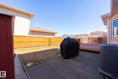 Private backyard featuring a wooden fence, concrete patio, and a multi-level wooden deck - 5736 161 Avenue, Edmonton, AB - Outdoor With Exterior