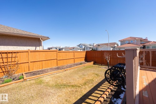 Expansive backyard featuring a stained wood privacy fence, a wooden deck, and a planted garden bed - 5736 161 Avenue, Edmonton, AB - Outdoor