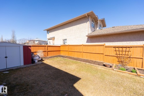 Fenced backyard featuring a manicured lawn, established garden beds, and a storage shed - 5736 161 Avenue, Edmonton, AB - Outdoor