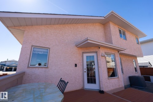 Rear exterior featuring stucco finish, white trim, and multiple windows - 5736 161 Avenue, Edmonton, AB - Outdoor With Exterior