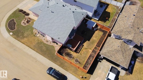 Corner lot property featuring a light-colored asphalt shingle roof, a private fenced yard, a wooden deck, and established perimeter landscaping - 5736 161 Avenue, Edmonton, AB - Outdoor