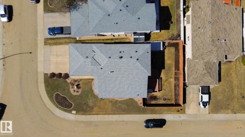 Single-family residence featuring a grey shingled roof, a corner lot position, a concrete driveway, a front yard with established landscaping, and a fenced backyard area - 5736 161 Avenue, Edmonton, AB - 