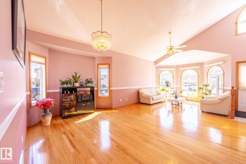 Living area featuring vaulted ceilings, wood-finish flooring, a bay window with arched transoms, and a ceiling fan - 5736 161 Avenue, Edmonton, AB - Indoor Photo Showing Living Room