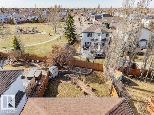 Expansive backyard featuring a fenced perimeter, fire pit, and stone retaining walls - 7 Doucette Place, St. Albert, AB - Outdoor