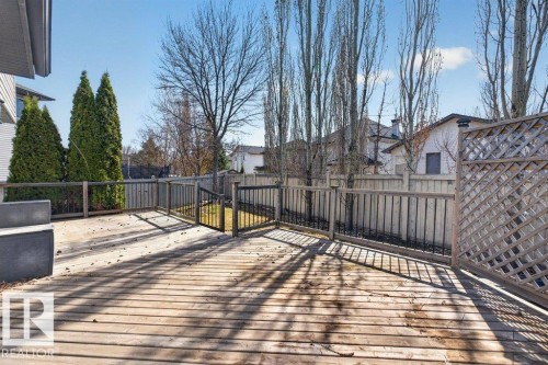Expansive wood deck with a privacy lattice panel, wood railing, and metal balusters - 10 Erickson Close, St. Albert, AB - Outdoor With Exterior