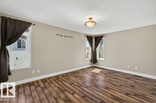 Spacious room featuring wood-finish flooring, light-toned walls, and white trim - 10 Erickson Close, St. Albert, AB - Indoor Photo Showing Other Room