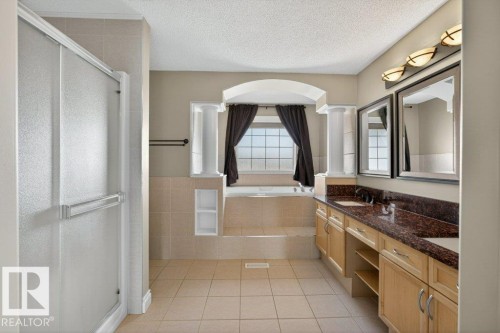Bathroom featuring a built-in tub, separate shower, double vanity with stone countertops, and integrated mirrors - 10 Erickson Close, St. Albert, AB - Indoor Photo Showing Bathroom