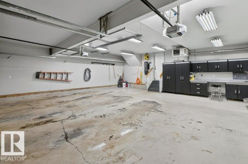 Spacious garage with built-in dark cabinetry and ample countertop workspace - 10 Erickson Close, St. Albert, AB - Indoor Photo Showing Garage