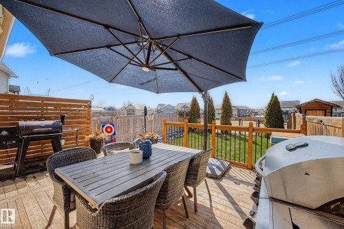 Spacious wood-finish deck featuring a privacy screen and a dedicated grilling area - 2083 Chalmers Way, Edmonton, AB - Outdoor With Deck Patio Veranda With Exterior