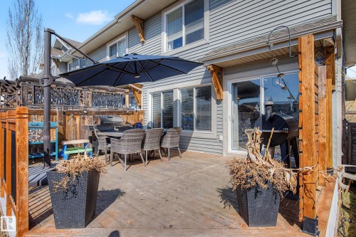 Spacious outdoor deck featuring wood flooring and a privacy fence with decorative metal panels - 2083 Chalmers Way, Edmonton, AB - Outdoor