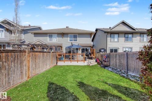 Expansive fenced backyard featuring a manicured lawn, an elevated wood deck, and a multi-level wood staircase - 2083 Chalmers Way, Edmonton, AB - Outdoor