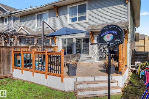 Expansive back deck featuring wood railing with black metal spindles and a two-step entry - 2083 Chalmers Way, Edmonton, AB - Outdoor