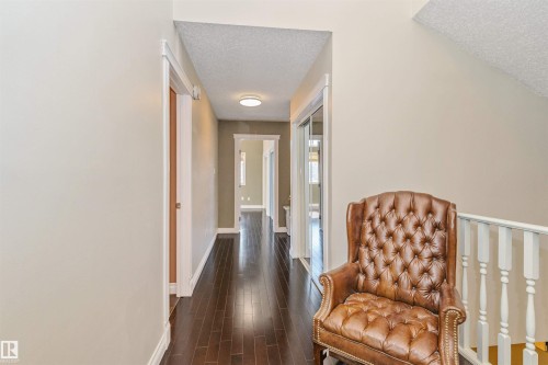 Hallway featuring dark wood-finish flooring, light neutral wall paint, and white trim - 6016 177 Street, Edmonton, AB - Indoor Photo Showing Other Room
