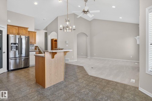 Vaulted ceilings defining a spacious living area with light gray carpeting and a white mantelpiece - 34 3003 34 Avenue, Edmonton, AB - Indoor Photo Showing Kitchen