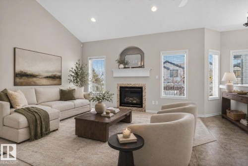 Vaulted ceiling living area featuring a gas fireplace with stone surround, recessed lighting, multiple windows with blinds, and neutral wall tones - 34 3003 34 Avenue, Edmonton, AB - Indoor Photo Showing Living Room With Fireplace