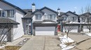 Townhome exterior featuring light gray siding, dark trim, an attached garage with a white door, and a concrete driveway - 34 3003 34 Avenue, Edmonton, AB  - Outdoor With Facade 