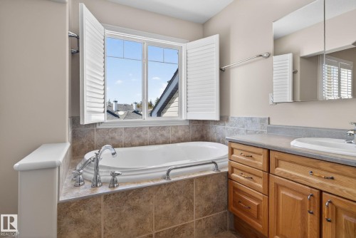 Built-in soaking tub with chrome fixtures, surrounded by ceramic tile and featuring plantation shutters - 34 3003 34 Avenue, Edmonton, AB - Indoor Photo Showing Bathroom