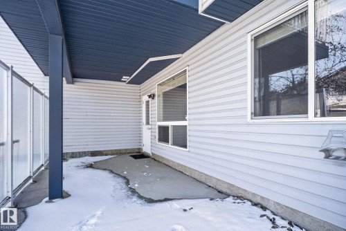 Covered patio area featuring a dark blue soffit, a solid support column, and a light-colored privacy screen - 34 3003 34 Avenue, Edmonton, AB - Outdoor With Exterior