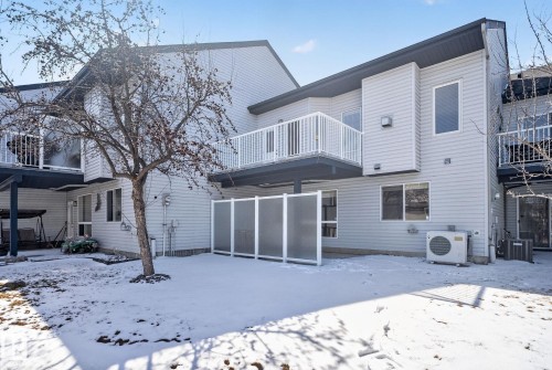 Light gray siding exterior with a lower level patio and an upper-level balcony featuring white railings - 34 3003 34 Avenue, Edmonton, AB - Outdoor