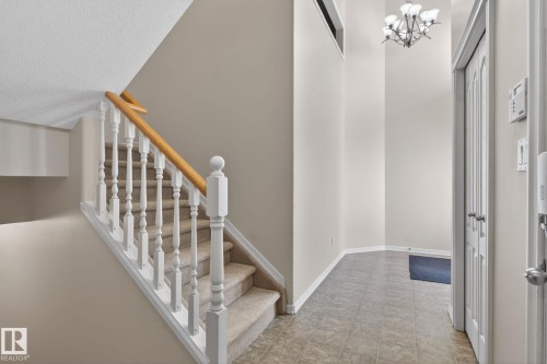 Staircase featuring carpeted treads, white balusters, and a light wood-finish handrail - 34 3003 34 Avenue, Edmonton, AB - Indoor Photo Showing Other Room