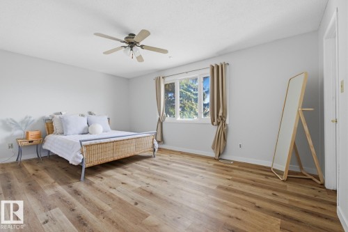 Bright room featuring wood-finish flooring, a multi-pane window, and a ceiling fan with integrated lighting - 17604 85 Avenue, Edmonton, AB - Indoor Photo Showing Bedroom