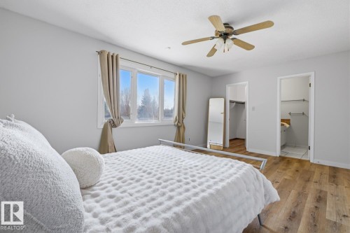 Spacious room featuring wood-finish flooring, a multi-pane window, and a ceiling fan with integrated lighting - 17604 85 Avenue, Edmonton, AB - Indoor Photo Showing Bedroom