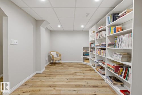 Extensive built-in shelving with a curved corner, wood-finish flooring, recessed lighting, white baseboards, and a drop ceiling - 17604 85 Avenue, Edmonton, AB - Indoor