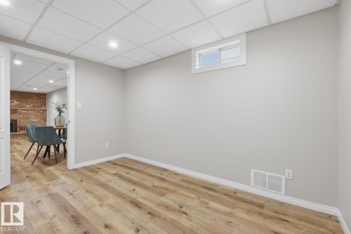 Open room featuring wood-finish flooring, light gray walls, and white baseboards - 17604 85 Avenue, Edmonton, AB - Indoor Photo Showing Other Room