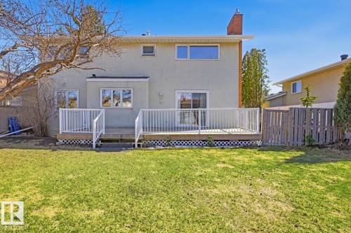 Expansive rear yard featuring a wooden deck with white railings, a sliding glass door, and a stucco exterior - 17604 85 Avenue, Edmonton, AB - Outdoor With Deck Patio Veranda