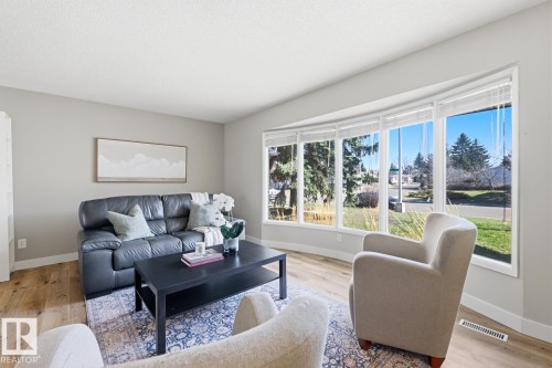 Living area featuring a prominent bay window, light wood-finish flooring, a neutral wall color, and white trim - 17604 85 Avenue, Edmonton, AB - Indoor Photo Showing Living Room