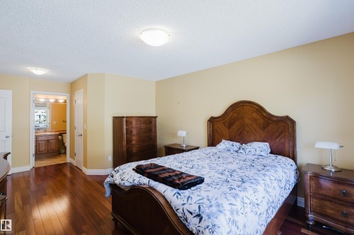 Spacious room featuring wood-finish flooring, light yellow walls, and a textured white ceiling - 9 102 Bridgeport Crossing, Leduc, AB - Indoor Photo Showing Bedroom