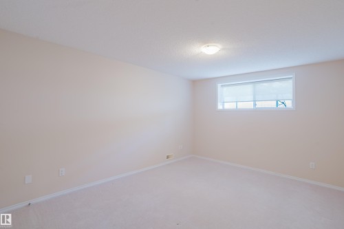 Spacious room with light-colored walls and wall-to-wall carpeting - 9 102 Bridgeport Crossing, Leduc, AB - Indoor Photo Showing Other Room