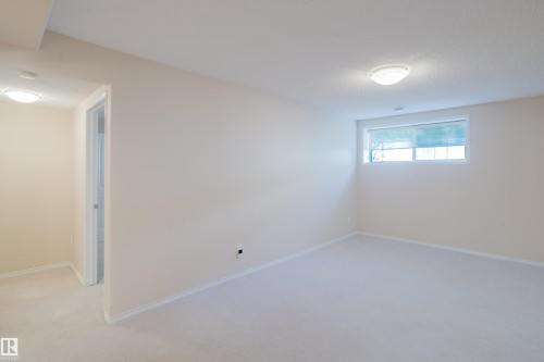 Carpeted room with neutral wall tones and white baseboards - 9 102 Bridgeport Crossing, Leduc, AB - Indoor Photo Showing Other Room
