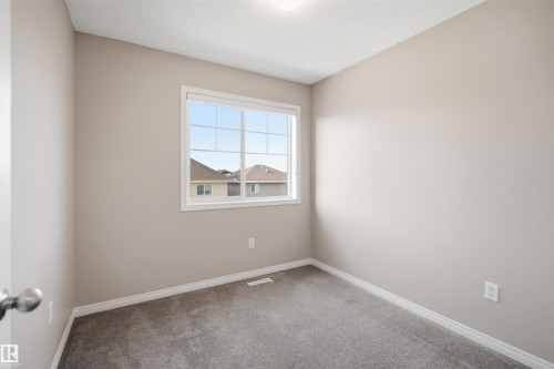 Room with light gray walls, gray carpeting, and white baseboards - 33 7385 Edgemont Way Nw, Edmonton, AB - Indoor Photo Showing Other Room