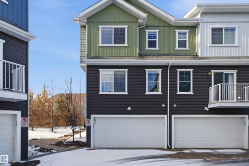 Contemporary townhome facade featuring multi-colored siding, white window trim, and a second-story balcony - 33 7385 Edgemont Way Nw, Edmonton, AB - Outdoor