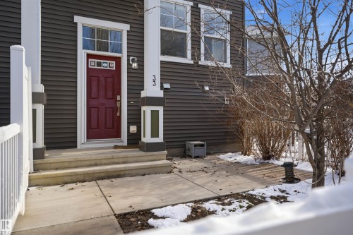 Siding exterior with a red entry door and white trim - 33 7385 Edgemont Way Nw, Edmonton, AB - Outdoor