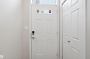 White paneled entry door with transom window, electronic keypad lock, and brushed nickel hardware - 33 7385 Edgemont Way Nw, Edmonton, AB  - Indoor Photo Showing Other Room 