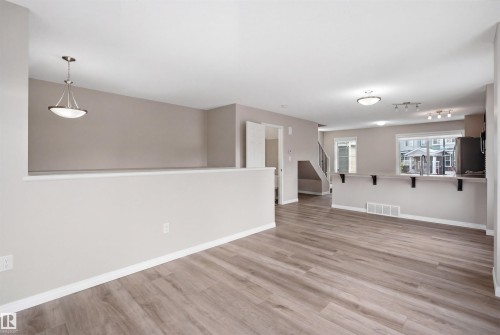 Open-concept living area featuring wood-finish flooring, neutral wall tones, and recessed lighting - 33 7385 Edgemont Way Nw, Edmonton, AB - Indoor Photo Showing Other Room